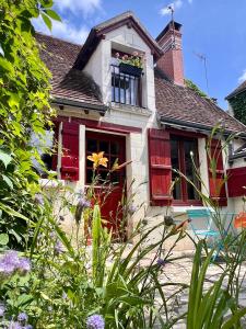 una casa con una porta rossa e una finestra di Le Cottage des Chalands a Saint-Georges-sur-Cher