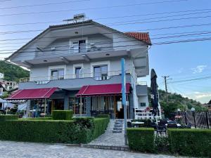 a building with red awnings in front of it at Eiffel's Guest House in Pogradec