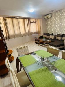 uma sala de estar com uma mesa e um sofá em Lux Apartment Sisi em Burgas