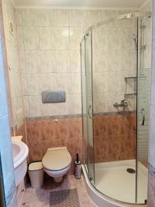 a bathroom with a toilet and a glass shower at Lux Apartment Sisi in Burgas
