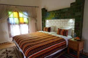 a bedroom with a large bed and a window at Riad Zagora Palms in Zagora