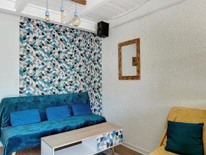 a living room with a blue couch and a mirror at Escapade marine a carnac Maison 4 personnes toute équipée, au calme entre plage et ville in Carnac