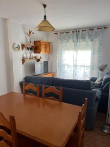 a living room with a blue couch and a table at Apartamento La Atalaya C-162 in Conil de la Frontera
