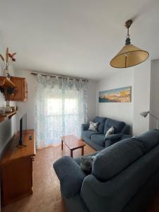 a living room with a blue couch and a tv at Apartamento La Atalaya C-162 in Conil de la Frontera