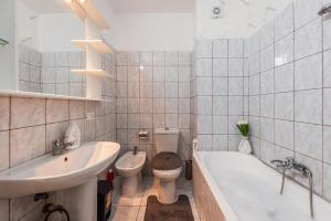 a bathroom with a sink and a toilet and a tub at Magic Sea View in Durrës +22 photos