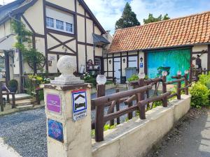 um sinal em frente a um edifício com uma cerca em Le Vieux Logis em Neufchâtel-Hardelot