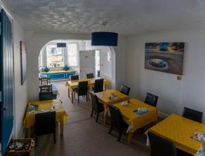 un comedor con mesas y sillas amarillas en Sea Jade Guest House, en Bude