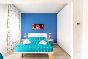 a blue bedroom with a bed and a blue wall at Modern Studio della Valle x2 in Padova