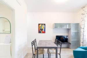 a dining room with a table and chairs and a tv at Modern Studio della Valle x2 in Padova