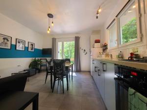a kitchen and dining room with a table and chairs at La Dame de cœur 05 in Antonaves