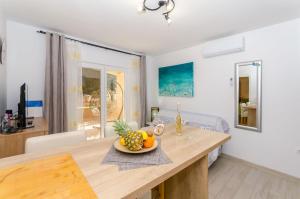 a kitchen with a table with a bowl of fruit on it at Apartments Apollo in Zastražišće