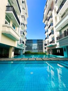 a swimming pool in the middle of two apartment buildings at 2 BR 5 pax Spacious Elegant Condo in Saint Dominique, Megaworld, Iloilo City in Iloilo City