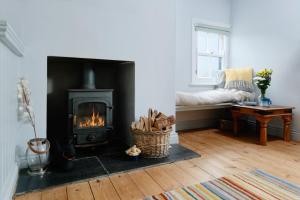 een woonkamer met open haard en een bank bij Corner Cottage in Penzance
