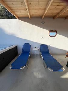 duas cadeiras azuis e uma mesa num quarto em Mano's House em Triopetra