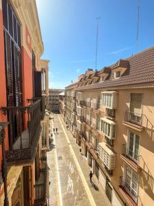 a city street with buildings and people walking around at Apartamentos Loles De Cisneros Catedral in Málaga