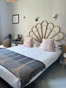 1 dormitorio con 1 cama grande y cabecero grande en Hôtel Eden - La Baigneuse en Juan-les-Pins