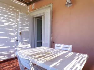 a white table and chairs in a room with a door at L'Isolana Case Vacanza Alloro 1 in Ponza