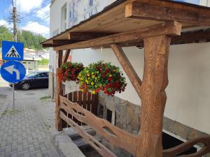a wooden building with flowers on the side of a building at Camera de familie in Vatra Dornei
