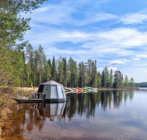 a tent on a dock on a lake with boats at Pytkyn Kämppä in Syöte