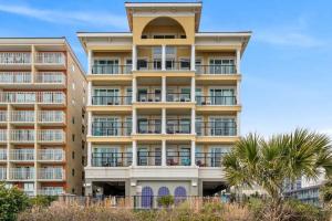 a large apartment building with palm trees in front of it at Bali Bay Resort in Myrtle Beach