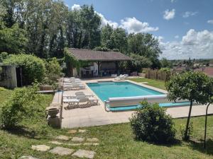 a swimming pool with chairs and a gazebo at Castle Of Saint Germain Des Rives in Saint-Germain-des-Rives