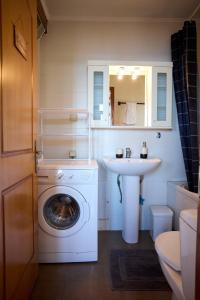 a bathroom with a washing machine and a sink at Windmills Apartments Chios in Chios