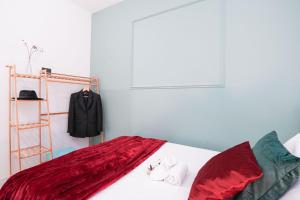 a bedroom with a bed with red sheets and a clothes rack at Maison Métropole Turin in Turin