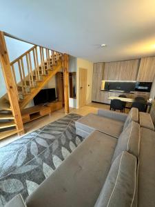 a living room with a couch and a staircase at Vila Vika in Palanga