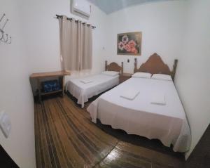 Ένα ή περισσότερα κρεβάτια σε δωμάτιο στο Casa Flor do Ipê Homes