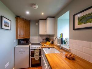 cocina con electrodomésticos blancos y encimera de madera en 1 Bed in Knighton 51897, en Beguildy