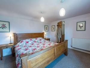 1 dormitorio con 1 cama con colcha de flores en 1 Bed in Knighton 51897, en Beguildy