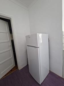 a white refrigerator in a room with a door at Boa Noite Casa de Hospedes in Lisbon