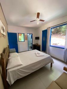 a bedroom with a bed and a ceiling fan at Embaúbas suíte privativa in Serra do Cipo