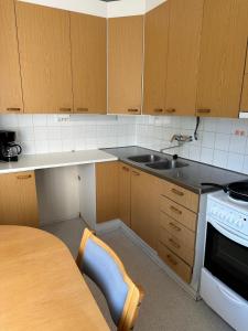 a kitchen with a table and a sink and a stove at Vehkaojan Kotoisa in Jämsä +6 photos