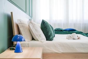a bed with green and white pillows in a room at Maison Turin in Turin
