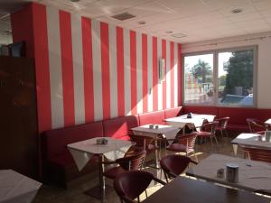 a restaurant with red and white striped walls and tables at Hotel Marco Effe in Mestrino
