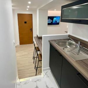 a kitchen with a sink and a wooden door at General Suite - Strasbourg Hyper Centre in Strasbourg
