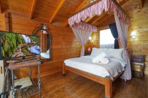 a bedroom with a bed in a log cabin at הפינה היפה של צביה in Had Nes