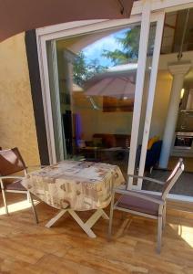 una mesa y 2 sillas y una sombrilla en una habitación en Dépendance Spacieux Duplex 50 M2 Classé 3 étoiles sans vis-à-vis en Gréoux-les-Bains