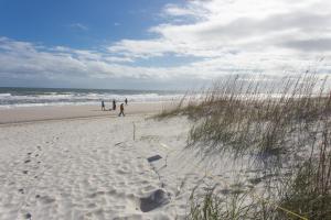 a group of people walking on the beach at Comfortable One Bedroom Apartment - Walk to the Beach! in Jacksonville Beach +5 photos