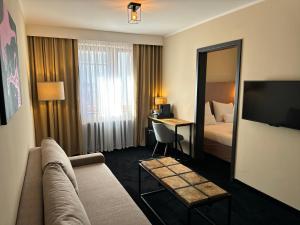 Pokój hotelowy z kanapą, łóżkiem i biurkiem w obiekcie Amber Blue Wellness & SPA w Karwii