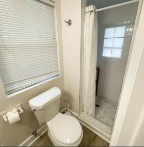 a white bathroom with a toilet and a shower at Comfortable One Bedroom Apartment - Walk to the Beach! in Jacksonville Beach