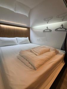 Un dormitorio con una cama grande con luz. en POTATO Boutique Hostel, en Singapur 17 fotos más