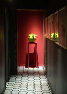 那不勒斯Costantinopoli 33 Grand Suite的红色的走廊，桌子上有一个绿色的花瓶 更多42张照片