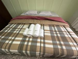 1 cama con 2 almohadas y toallas en Suíte na casa amarela en Pomerode