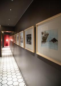 那不勒斯Costantinopoli 33 Grand Suite的墙上一排画的走廊