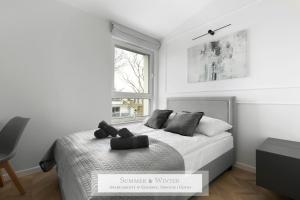 a white bedroom with a bed and a window at 4 stars, Luxury Butterfly & Bike Apartments, Gdynia Orłowo, 15 mieszkań, z oddzielną sypialnią, windą i płatnym parkingiem, blisko drog rowerowych, niedaleko molo, golf, stadnina, adventure park, SUMMERWINTER Brand in Gdynia +193 photos