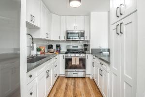 eine Küche mit weißen Schränken und Geräten aus Edelstahl in der Unterkunft 2BR-2BA Close to Waikiki Beach with Free Parking! in Honolulu