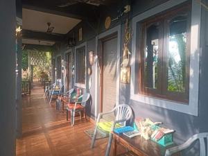 una habitación con sillas y mesas en un porche en The Caveman Goa-River-view Retreat., en Arambol