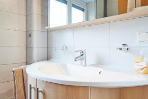 łazienka z białą umywalką i lustrem w obiekcie Apartments Kirchebnerhof w mieście Oetz